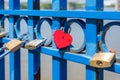 Messages of love locked to a blue wrought iron fence