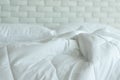 Messed bed with white pillow and blanket with natural light in bedroom in the morning Royalty Free Stock Photo