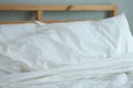 Messed bed with white pillow and blanket with natural light in bedroom in the morning Royalty Free Stock Photo