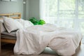 Messed bed with white pillow and blanket with natural light in bedroom Royalty Free Stock Photo