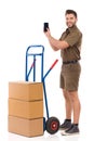 Messenger Is Standing Close To A Push Cart, Holding Smartphone And Pointing At It