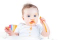 Messy baby eating her first solid vegetable food Royalty Free Stock Photo