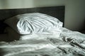 Messy bed, bed sheet and pillow in a hotel room Royalty Free Stock Photo