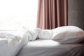 Messy bed. Side view. White pillow, blanket and bed cover sheeet. Royalty Free Stock Photo