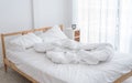 Messy bed in a white room in morning without people Royalty Free Stock Photo