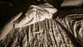 A messy bed with wrinkled sheets and high contrast at night Royalty Free Stock Photo