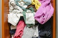 Messy closet filled with different used unfresh clothes, sloppily shoved,hanging from shelves. Fast fashion. Pile of Royalty Free Stock Photo