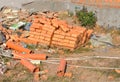 Messy construction site: a pile of red brick, staked bricks among construction waste or building garbage