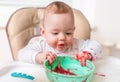 Messy and dirty baby is eating from bowl Royalty Free Stock Photo