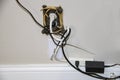 Messy electric cords - too many plugged into one decorative electrical outlet plus cable - all in a tangle