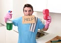 Messy man in stress in washing gloves holding sponge and detergent spray bottle asking for help Royalty Free Stock Photo