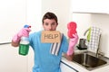 Messy man in stress in washing gloves holding sponge and detergent spray bottle asking for help Royalty Free Stock Photo