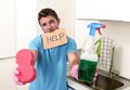 Messy man in stress in washing gloves holding sponge and detergent spray bottle asking for help Royalty Free Stock Photo