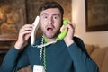 Messy man using two landline telephones at the same time Royalty Free Stock Photo