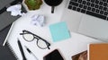 Messy office desk with laptop, sticky note, notebook and supplies. Royalty Free Stock Photo