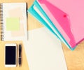 Messy office table with smartphone, notepad and filling folders. View from above Royalty Free Stock Photo