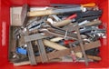 Messy old rusty hand tools in a red plastic box