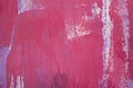 Messy paint strokes and smudges on an old painted wall background. Abstract pink wall surface with part of graffiti Royalty Free Stock Photo