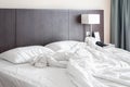 Messy and unmade white hotel bed at hotel room in holiday morning Royalty Free Stock Photo