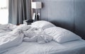 Messy and unmade white hotel bed at hotel room in holiday morning Royalty Free Stock Photo