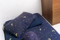 Messy untidy bedroom with wrinkle mattress pillow and blue sheet and wooden drawer Royalty Free Stock Photo