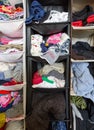 Messy untidy wardrobe closeup with colorful clothes for men, women, baby