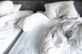 Messy white bedding sheets and pillows with wrinkles on bed Royalty Free Stock Photo