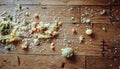 Messy wooden floor scattered with rice grains and vegetable bits after baby first solid feeding Royalty Free Stock Photo