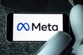 META company logo on smartphone next to Oculus joy cons, touch controllers.