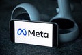 META company logo on smartphone next to Oculus joy cons, touch controllers.