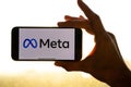 Meta logo on the iPhone. Woman holding smartphone