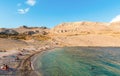 People on amazing sandy beach surrounded by rocky hills. Rucica beach on Pag island in Croatia.