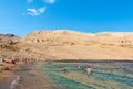 People on amazing sandy beach surrounded by rocky hills. Rucica beach on Pag island in Croatia.