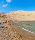 People on amazing sandy beach surrounded by rocky hills. Rucica beach on Pag island in Croatia.