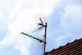 Metal antenna and satellite signal receiver on sloped clay roof