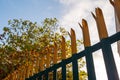 Metal anti climbing fence with spikes on top. Secure perimeter of property. Blue cloudy sky Royalty Free Stock Photo