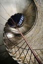 Metal antique spiral staircase with handrails in a stone tower.