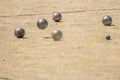 Metal ball from the game of petanque approaching the bowling ball bouncing on the sandy ground raising dust from a petanque court Royalty Free Stock Photo