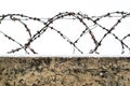 Metal barbed wire on the stone fence  on the background of winter sky Royalty Free Stock Photo