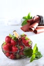 Metal basket with fresh strawberries. Strawberry pastille is rolled into a tube. Natural product. Copy of the space. Vertical