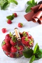 Metal basket with fresh strawberries. Strawberry pastille is rolled into a tube. Natural product. Copy of the space. Vertical