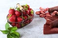 Metal basket with fresh strawberries. Strawberry pastille is rolled up in a tube. Natural product. Dried fruit from strawberries.