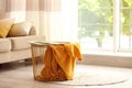 Metal basket with yellow blanket in room, space for text. Idea for interior design