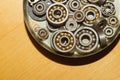 Metal bearings in a box on a wooden background. pile of gears