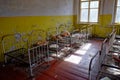 Metal bed frames in a dilapidated room. Old childrens beds in an abandoned kindergarten. The interior of a room in one of the Royalty Free Stock Photo