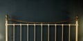 Metal bed headboard on black wall background, copy space Royalty Free Stock Photo