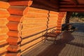 Metal bench in log cabin porch under evening sun light Royalty Free Stock Photo