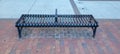 Metal bench on red brick sidewalk in background Royalty Free Stock Photo