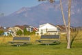 Metal benches on a park against homes and mountain Royalty Free Stock Photo