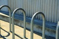 Metal bike rack arches for securing and chaining bicycle on side of metal building in urban downtown area of city